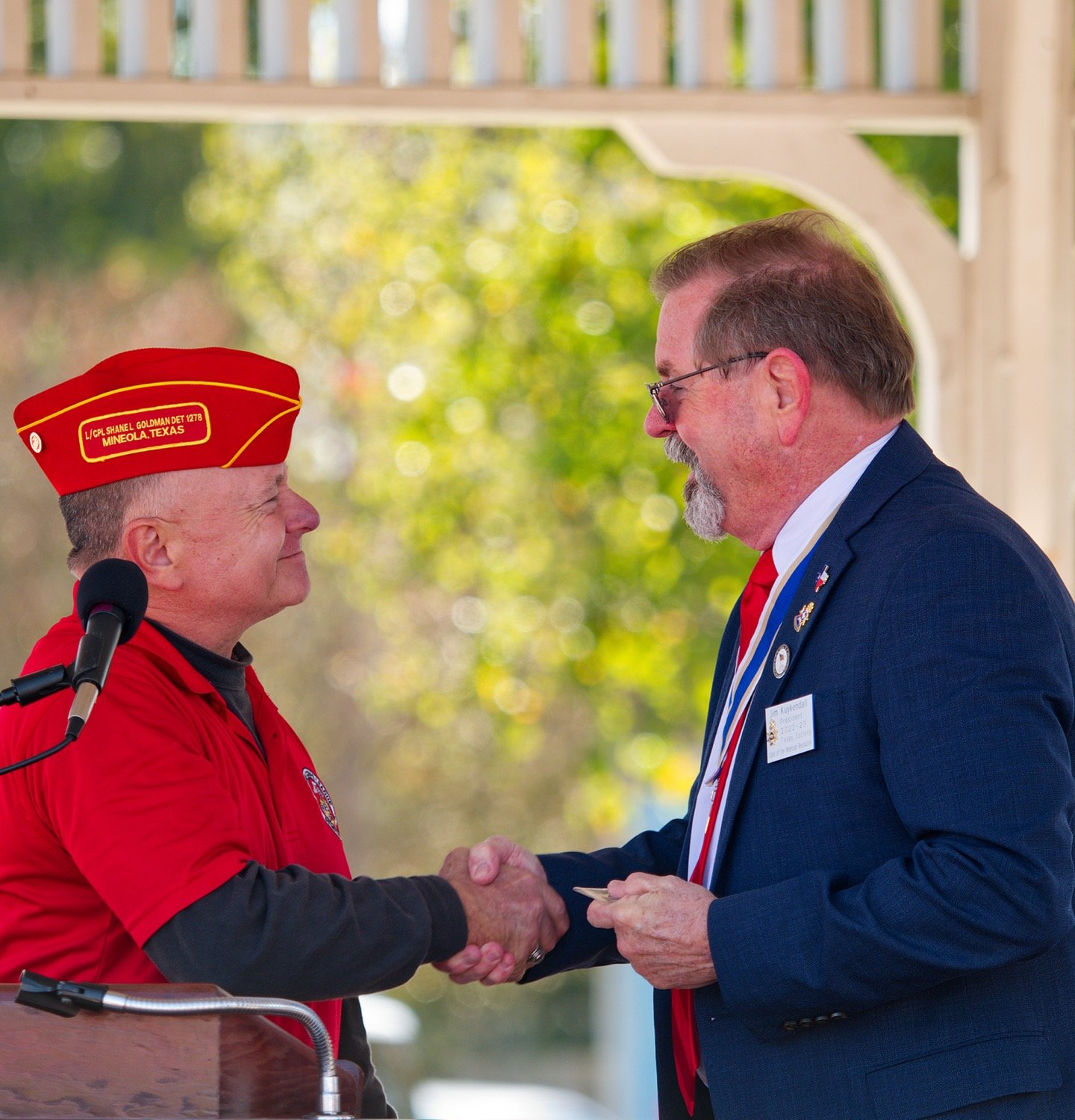 Wesley Marsh, emcee for the Marine Corp. League's ceremony for Veterans Day, shakes the hand of Jim Kuykendall, president of the Texas Society of Sons of the American Revolution, who he presented with a challenge coin after his speech. [view more vets]